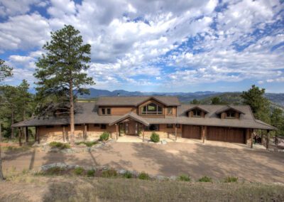 A home with a large driveway in the mountains.