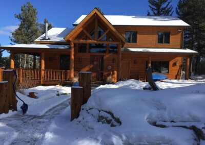 A log cabin in the snow covered in snow.