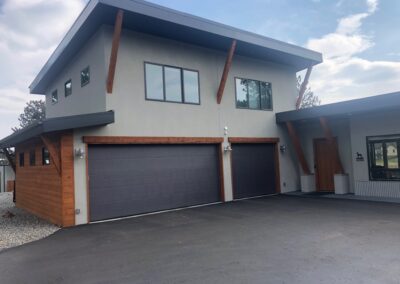 A modern home with two garages and a driveway.