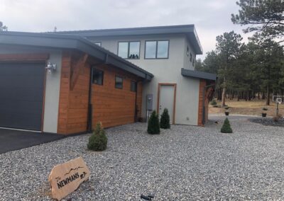 A home with a garage and gravel in front of it.