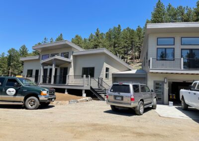 Two trucks are parked in front of a house.