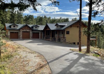 A home with a driveway and garage in the woods.